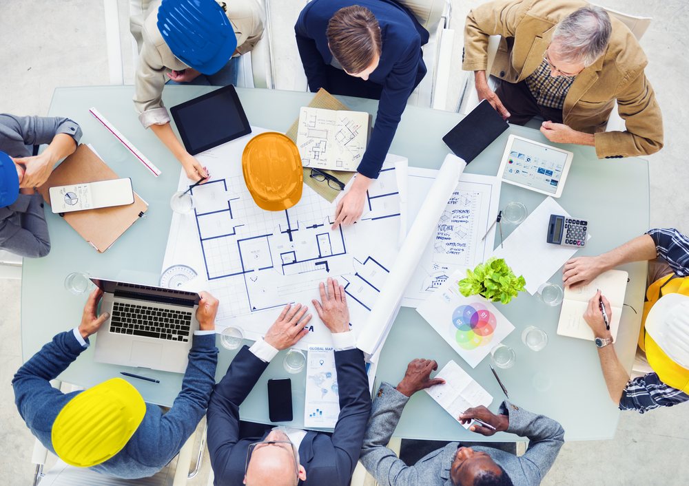 Equipe de engenharia em reunião técnica analisando documentação de projeto